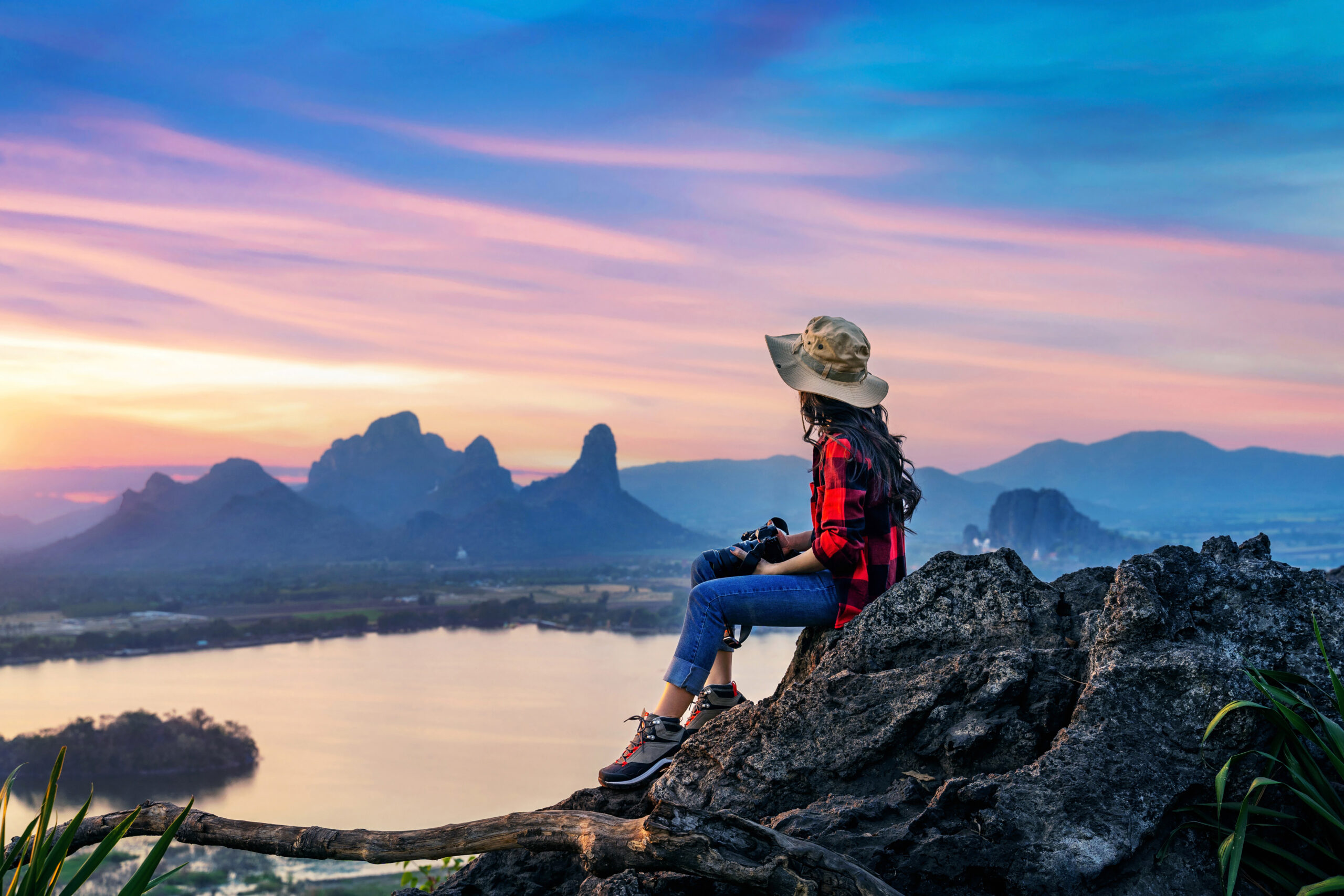 Tourist sitting on Phu sub lek viewpoint at sunset, Lopburi, Tha